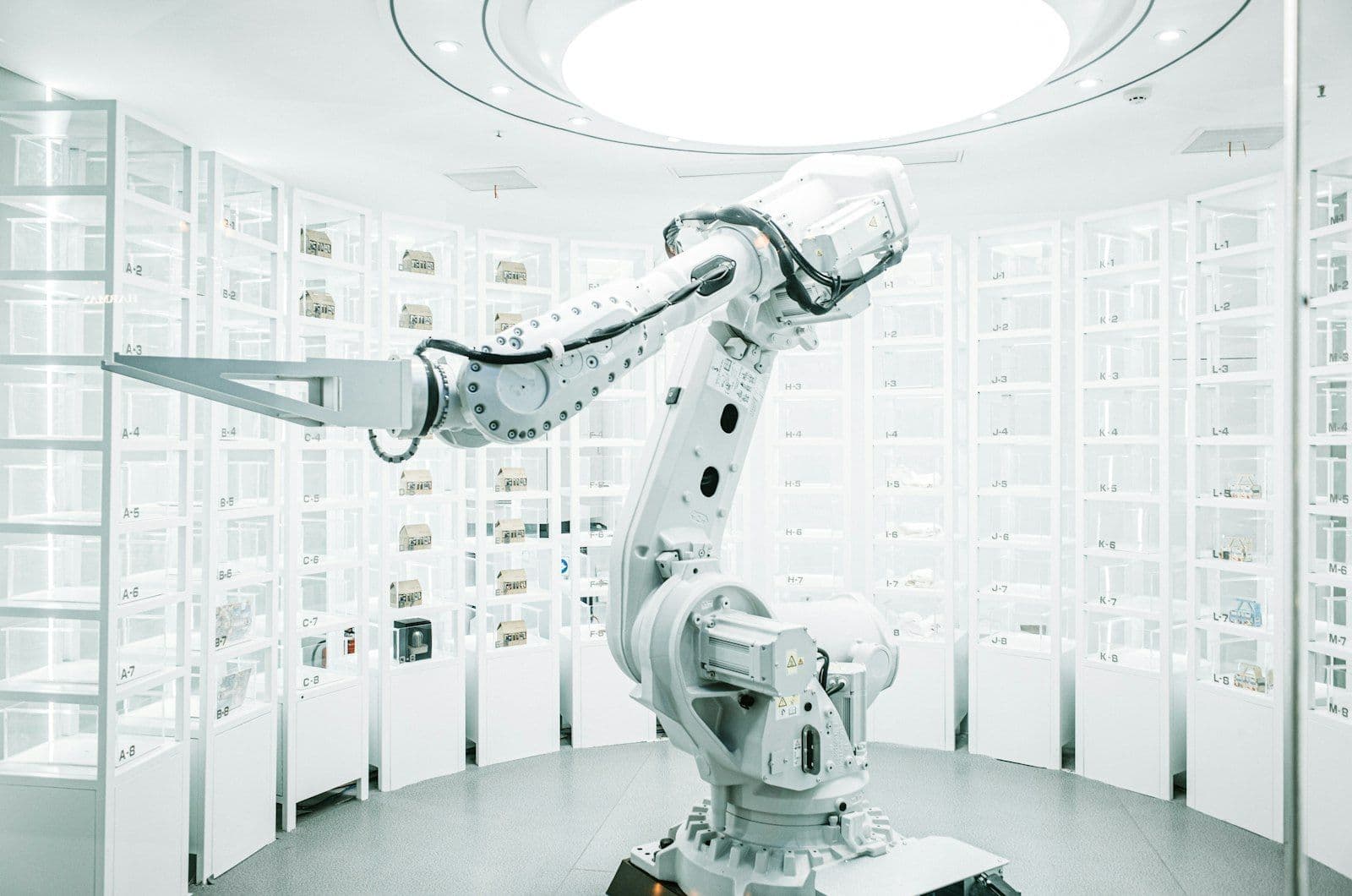 A white industrial robot arm in a bright, white room